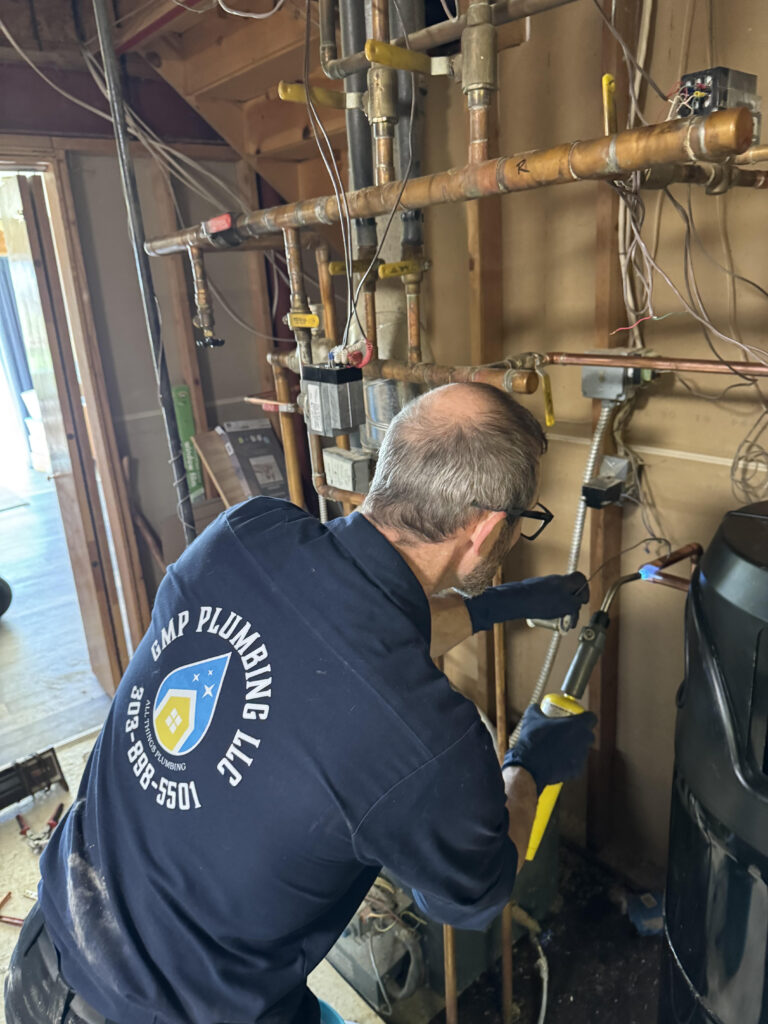 Professional tank water heater installation with gas line and pipe connections