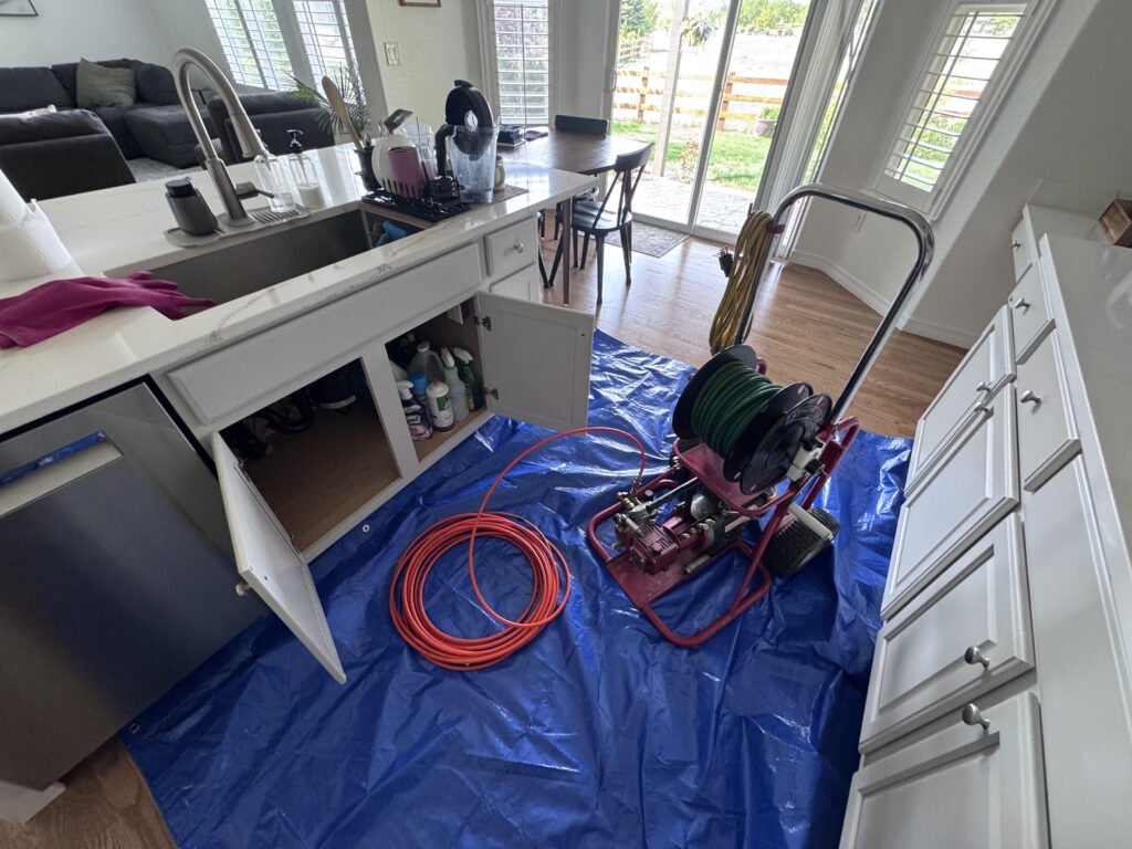 Professional hydro-jetting service clearing sewer line blockage with high-pressure water equipment